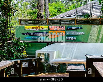 Panneau directionnel peint à la main au resort GoldenEye, Jamaïque, indiquant aux visiteurs le chemin vers le Shabeen, la piscine, le bureau, les cabanes de plage, Button Beach, Flemin Banque D'Images
