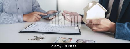 Real estate agents expliquer le document pour les clients qui viennent au contact d'acheter une maison, acheter ou vendre un bien immobilier concept Banque D'Images