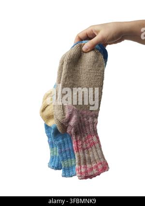 la main féminine tient une paire de chaussettes tricotées en laine, des vêtements chauds, l'article est isolé sur un fond blanc Banque D'Images