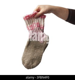 la main féminine tient une paire de chaussettes tricotées en laine, des vêtements chauds, l'article est isolé sur un fond blanc Banque D'Images