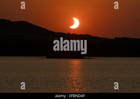 Éclipse solaire 2026 au coucher du soleil sur un paysage de lac et de montagne - Alcañiz - Espagne Banque D'Images