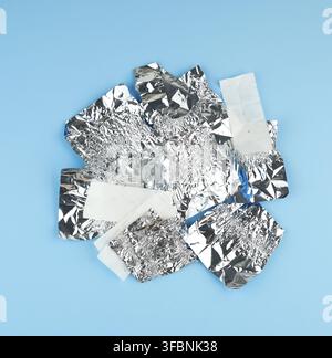 Divers Livre blanc froissé et d'aluminium utilisé des papiers de bonbons sur un fond bleu, vue du dessus Banque D'Images