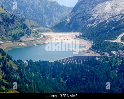 Lac sous le massif du Marmolada, le plus haut sommet des Dolomites (3 343 m), avec ses glaciers et ses falaises rocheuses, tel que vu depuis les pâturages verts de haute altitude Banque D'Images
