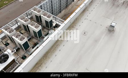 Vue aérienne de plusieurs unités de climatisation industrielles CVC installées sur un toit plat dans un cadre urbain à Riga, en Lettonie. Banque D'Images