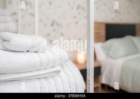 Serviettes blanches empilées apportant du confort dans une chambre moderne Banque D'Images