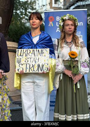 Londres, Royaume-Uni. 24 août 2026. Des femmes portant des couleurs ukrainiennes et des vêtements traditionnels participent à une réunion au monument Saint-Volodymyr sur Holland Park Avenue pour marquer le 35e anniversaire de l'indépendance de l'Ukraine. Crédit : Alexander Seale/Alamy Live News Banque D'Images