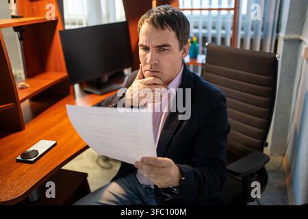 homme d'affaires occupé vérifiant des documents. un employé travaille avec des documents au bureau. Banque D'Images