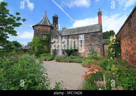 Le Gardener's Cottage au RHS Garden Bridgewater, Salford, entouré de conteneurs et de bordures remplis de plantes attrayantes pour les abeilles et les papillons. Banque D'Images