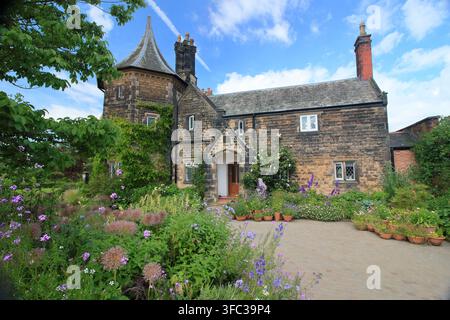 Le Gardener's Cottage au RHS Garden Bridgewater, Greater Manchester, entouré de pots et de bordures remplis de plantes attirant les pollinisateurs. Banque D'Images