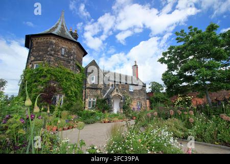 Le Gardener's Cottage au RHS Garden Bridgewater, Greater Manchester, entouré de pots et de bordures remplis de plantes attirant les pollinisateurs. Banque D'Images