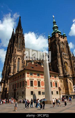 Prague, République tchèque – 28 juillet 2026 : des touristes visitent la cathédrale Saint-Guy au château de Prague, les tours gothiques s'élevant au-dessus de la troisième cour. Banque D'Images