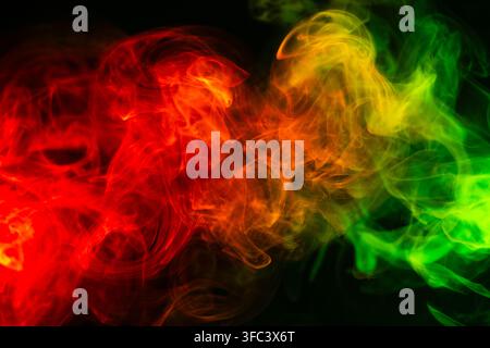 Fond abstrait de fumée coloré avec dégradé rouge, jaune et vert isolé sur noir. Banque D'Images