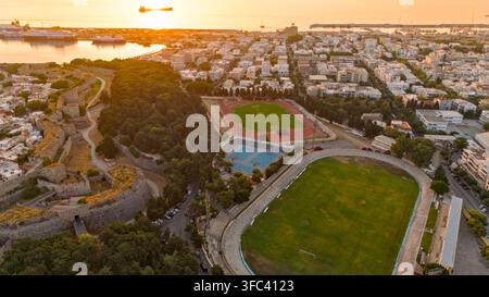 Vue aérienne des murs de forteresse, d'une piste d'athlétisme, de terrains de football et de courts de basket à Rhodes, en Grèce. Banque D'Images