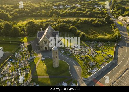 Vue aérienne de l'église Saint-Joseph et Saint-Conal avec son clocher rond et son cimetière, située au milieu de champs verdoyants et d'une route sinueuse à Bruckless Banque D'Images