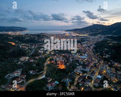 Vue aérienne de la ville de La Spezia au crépuscule, avec des bâtiments illuminés, le port et les collines environnantes le long de la côte ligurienne à La Sp Banque D'Images