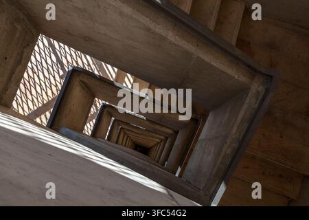 Une cage d'escalier en béton s'enroule vers le bas dans un motif géométrique frappant de formes rectangulaires en retrait, Valletta, Malte Banque D'Images