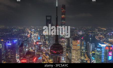 Vue aérienne de la skyline illuminée de Lujiazui la nuit, mettant en scène l'emblématique tour de la Perle de l'Orient entourée de gratte-ciel lumineux et de lumières de la ville Banque D'Images