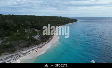 Vue imprenable sur l'eau turquoise cristalline entourant le rivage de sable blanc de l'île de Jaco, une destination spectaculaire au Timor-Leste Banque D'Images