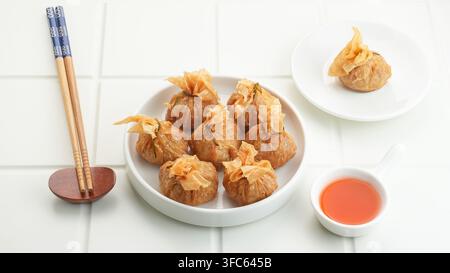 Ekado, sac d'argent traditionnel de nourriture thaïlandaise ou sac doré en entrée, wonton croustillant garni de poulet et d'œufs de caille. Banque D'Images