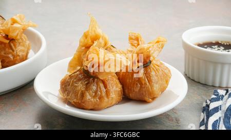 Ekado, sac d'argent traditionnel de nourriture thaïlandaise ou sac doré en entrée, wonton croustillant garni de poulet et d'œufs de caille. Banque D'Images
