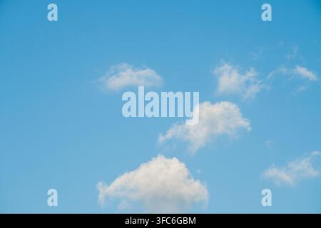 Le ciel était d'un bleu éclatant rempli de nuages blancs doux et duveteux. L'atmosphère est celle d'une journée ensoleillée avec des nuages cumulus dispersés dans tout le ciel. Banque D'Images