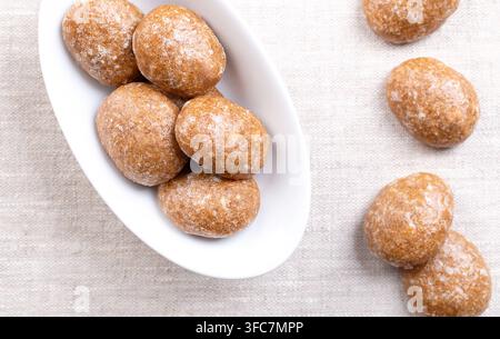 Biscuits sablés, biscuits de Noël glacés au sucre, dans un bol ovale blanc sur lin. Biscuits épicés faits de farine, de sucre et d'œufs, aromatisés aux épices. Banque D'Images