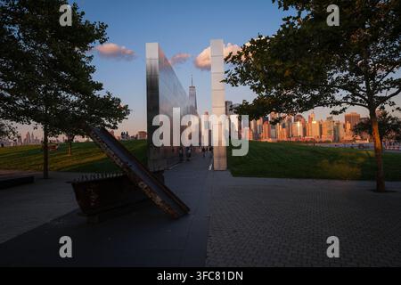 Le mémorial Empty Sky et la ligne d'horizon de Manhattan dans la lumière dorée. Jersey City, New Jersey, États-Unis, 15 août 2026. Banque D'Images