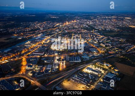 Vue aérienne de la zone industrielle et du paysage urbain de Sausheim la nuit, mettant en vedette des bâtiments illuminés, des entrepôts et des réseaux routiers. Sausheim Banque D'Images