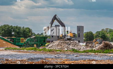 Des machines lourdes opèrent sur un chantier de construction où les ouvriers se préparent pour un nouveau développement immobilier. De gros équipements déplacent la terre et les matériaux autour t Banque D'Images