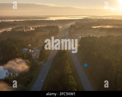 Vue aérienne de l'échangeur autoroutier A2 E77 près de Sigulda, Lettonie au lever du soleil avec circulation et brume matinale Banque D'Images