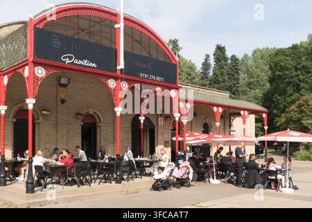Des gens assis à l'extérieur du pavillon du Heaton Park à Newcastle upon Tyne, Angleterre, Royaume-Uni Banque D'Images
