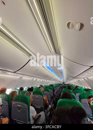 Vue intérieure d'une cabine d'avion commercial moderne montrant des passagers assis en rangées Banque D'Images