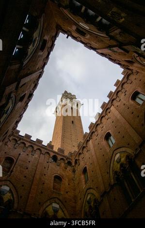 Sienne, Toscane, Italie - 8 octobre : Vue en contre-plongée de l'historique Torre del Mangia encadrée par les murs en briques de la cour du Palazzo Pubblico Banque D'Images