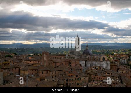 Sienne, Toscane, Italie - 8 octobre : Vue panoramique de la cathédrale de Sienne et des toits historiques avec des rayons de soleil traversant les nuages Banque D'Images