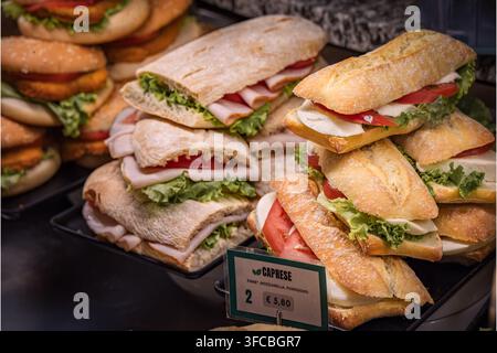 Sandwiches italiens Caprese en baguette avec mozzarella tranchée, tomates fraîches et laitue verte dans une vitrine d'un café, Vintimille, Italie Banque D'Images