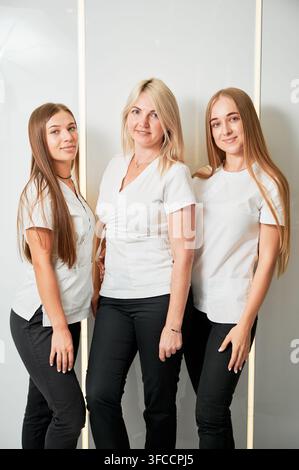 Portrait d'une équipe de dentistes professionnels. Jeunes médecins féminines souriant à l'appareil photo. Trois dentistes posant sur fond blanc. Banque D'Images