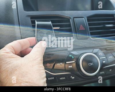 Close-up d'un support magnétique pour smartphone monté sur une bouche d'aération de voiture. Support magnétique universel pour téléphone portable à l'intérieur de la voiture. Accessoires automobiles Banque D'Images
