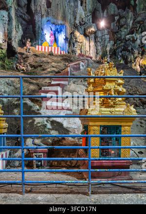 Gombak, Malaisie - 18 février 2025 : Un autel hindou doré et des marches de pierre à l'intérieur des grottes de calcaire du célèbre complexe templier de Batu Caves Banque D'Images