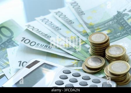 Une calculatrice et des pièces en euros sur la table Banque D'Images