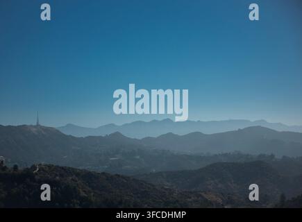 Panneau Hollywood et collines accidentées de Los Angeles, Californie, États-Unis, vus à travers le paysage montagneux brumeux des Hollywood Hills par une journée ensoleillée et claire Banque D'Images