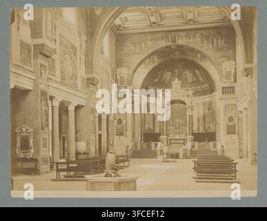 Intérieur de la Santa Prassede à Rome, Italie, Interno di Prassede, Roma, photographie, numéro : '137', Rome, 1851 - 1890, photographe, carton, papier, impression à l'albumine, impression albumique, hauteur 254 mm x largeur 354 mm, intérieur d'église, Basilica di Santa Prassede., Une vue intérieure sépia d'une grande nef d'église ornée avec un plafond à caissons élevé et une grande arche décorée menant à une abside contenant une zone d'autel en dôme ; les murs sont couverts de panneaux peints et de fresques et flanqués de colonnes et de pilastres, avec des reliefs sculpturaux décoratifs et des œuvres d'art encadrées visibles le long du côté Banque D'Images