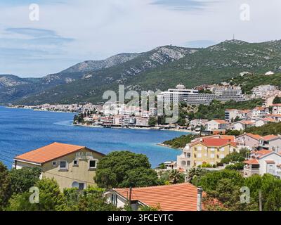 Une vue pittoresque de la ville côtière méditerranéenne de Neum, avec des maisons aux toits en terre cuite, des collines verdoyantes et les eaux bleu profond de la mer Adriatique. Banque D'Images