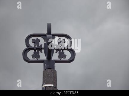 Une vue rapprochée d'une sculpture métallique décorative présentant des motifs complexes, sur fond de ciel nuageux dramatique à Cramahe. Cette image capture l'ar Banque D'Images