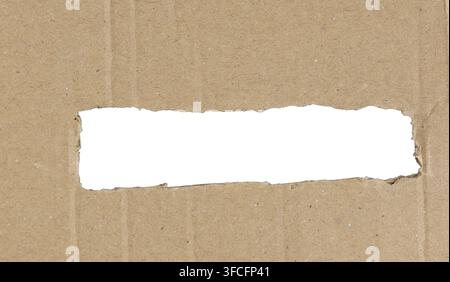 Trou déchiré dans une feuille de carton marron révélant un espace blanc isolé pour la copie Banque D'Images