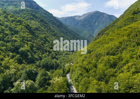Vue aérienne du parc national de Mavrovo mettant en scène une route sinueuse à travers des forêts luxuriantes et des montagnes à Mavrovo, Mavrovo et Rostusa, en Macédoine du Nord Banque D'Images