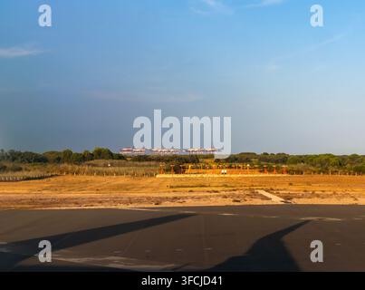 Aviation et infrastructure : Système d’éclairage d’approche de piste et grues portuaires au loin à l’aéroport Josep Tarradellas Barcelona-El Prat, Espagne Banque D'Images