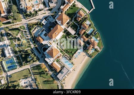 Photographie aérienne du resort de luxe One and Only Portonovi à Denovici, Herceg Novi, au Monténégro, montrant des villas aux toits rouges, des piscines, des jardins paysagers, une plage privée et la côte adriatique Banque D'Images