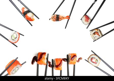 Cuisine japonaise et variété de sushi : baguettes tenant différents types de maki nigiri et roulés avec sauce sur fond blanc Banque D'Images