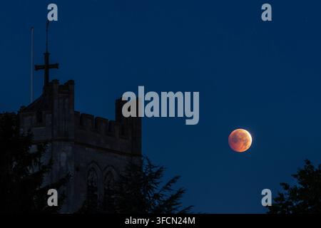WALTHAM ABBEY, ESSEX, UK. 28 août 2026. Une éclipse lunaire partielle est observée au-dessus de Waltham Abbey dans l'Essex aux petites heures du vendredi matin. Environ 93 % de la Lune est entrée dans la partie la plus sombre de l'ombre de la Terre au moment de l'éclipse maximale peu après 5h12 BST, donnant à la Lune une apparence rougeâtre. Banque D'Images