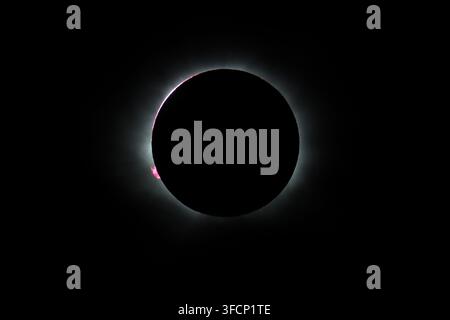 Premier instant d'éclipse solaire totale, avec une protubérance (petites boucles de gaz rose provenant du Soleil), vue au large de la côte nord-ouest de l'Islande, le 12 août 2026 Banque D'Images